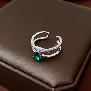 Detail eines silbernen zweilagigen offenen Rings mit grünem Edelstein auf Schmuckbox