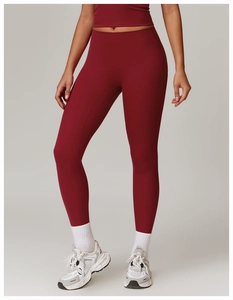 Detail showing high-waist yoga pants in burgundy with a matte texture and sleek fit
