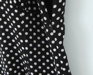 Détail de la fermeture éclair invisible sur une robe à pois vintage avec dentelle
