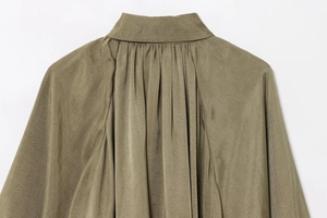Detailed view of gathered pleats on olive green bomber jacket neckline and lightweight fabric