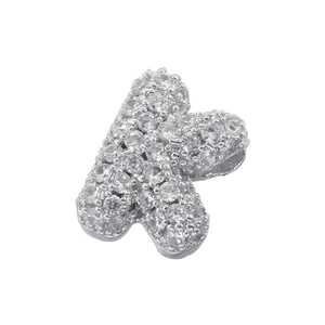 Macro shot of silver letter K pendant with 5A cubic zirconia stones on white background