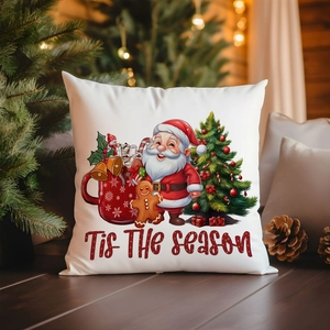 Housse de coussin de Noël en lin avec Père Noël posée sur un sol en bois chaleureux