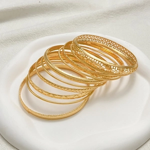 Detail of 10-piece gold alloy bangle set with intricate mesh and textured patterns