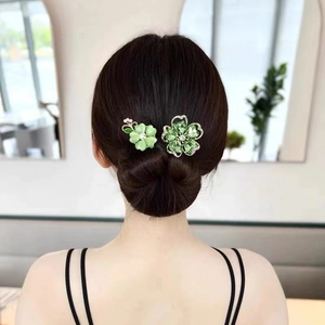 Vue arrière d'un mannequin portant d'élégantes pinces à cheveux fleurs vertes en chignon