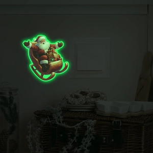 Luminous wall sticker showing Santa Claus on a sleigh glowing green in dark room