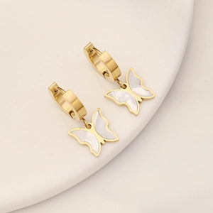 Detail of gold hoop earrings featuring elegant butterfly charms with white shell texture