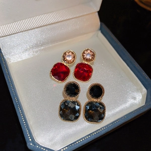 Vintage geometric stud earrings with red and black crystals in a blue jewelry box