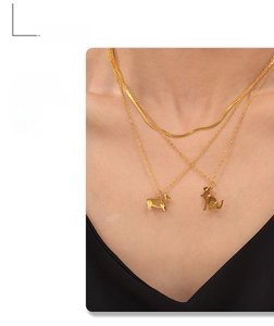 Detail of layered gold snake chain with Corgi and Cat silhouette pendants for women