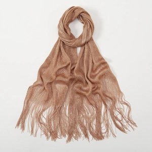 Detail of champagne gold metallic knit shawl showing long fringe tassels and mesh texture