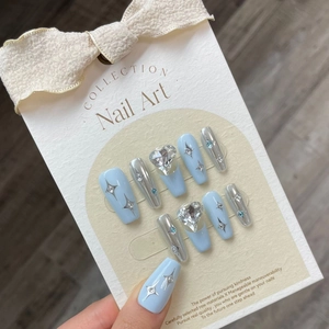 Handmade light blue press-on nails with heart rhinestones and silver star patterns