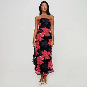 Detailed view of the layered mesh hem with red lily floral print on black tube dress
