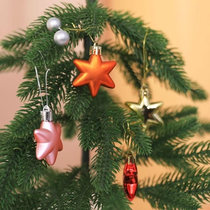 Macro shot of 5cm electroplated star and ball ornaments hanging on a Christmas tree
