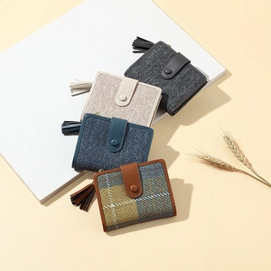 Detail of assorted small fabric wallets with tassels in a minimalist lifestyle setting