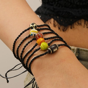 Detail view of 6-piece sports ball charm bracelets with adjustable black braided ropes