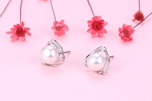 Detailed macro view of S925 silver hollow triangle earrings with white freshwater pearls