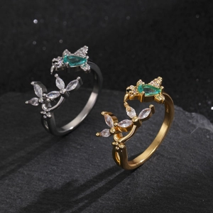 Macro detail of bird-inspired adjustable ring with emerald gemstone and white zircon