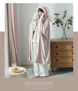 Cozy pink hooded blanket with rabbit ears and matching mittens in a warm home setting