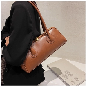 Detailed side view of a brown vintage Boston bag showing its size and premium texture