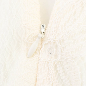 Detail of invisible zipper and 3D lace embroidery on a cream puff sleeve top