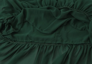 Detailed macro view of dark green chiffon fabric with pleated texture and hem stitching
