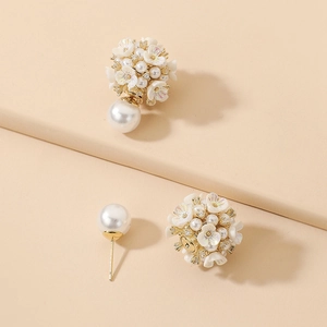 Detail showing the two-way wearing structure of floral earrings with pearls and crystals