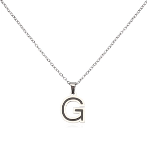Macro shot of silver stainless steel letter G pendant with black enamel filling detail