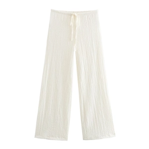 Detail view of white wide-leg trousers featuring drawstring waist and seersucker texture