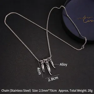 Punk style stainless steel necklace featuring three skull claw pendants on a black box