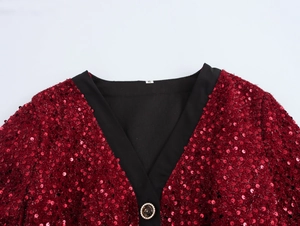 Dettaglio dello scollo a V in tweed rosso con bordo a contrasto e bottone decorativo