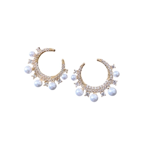 Gold-plated C-shaped earrings with sparkling cubic zirconia and white pearls on white base