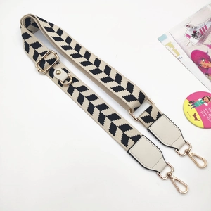Detail of adjustable black and white herringbone phone strap with gold metal swivel hooks