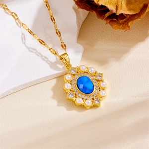 Close-up of vintage gold necklace featuring a blue oval stone with pearl and diamond halo