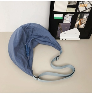 Détail du sac besace en nylon bleu marine avec bandoulière réglable et texture