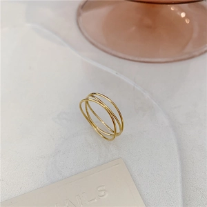 Detailed close-up of triple-layered 18K gold-plated interlaced ring on elegant minimalist surface