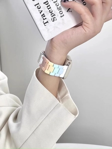 Detail view of macaron rainbow resin link band for Apple Watch worn with a white blazer