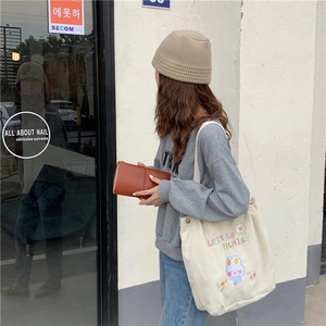 Détail du sac cabas en velours côtelé blanc avec broderie lapin et texte pique-nique