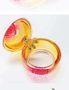 Macro view of pomegranate glass nail cup with golden handle and red-yellow gradient finish