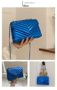 Detail view of electric blue patent leather shoulder bag with gold chain strap
