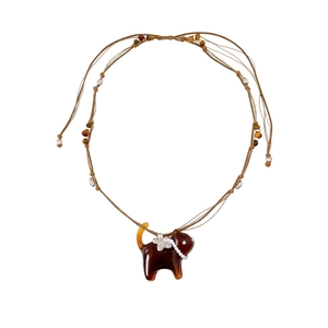Elegant cat pendant necklace with resin body and pearl flower detail on leather cord.