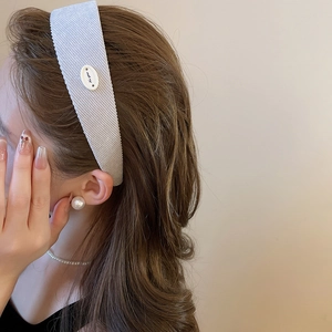 Détail d'un serre-tête en velours côtelé lavande avec étiquette et boucles d'oreilles