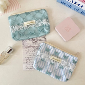 Detail of quilted floral coin purses with delicate white lace trim and bow embroidery