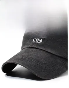 Detail view of the curved brim and white NYC embroidery on a black washed cotton cap