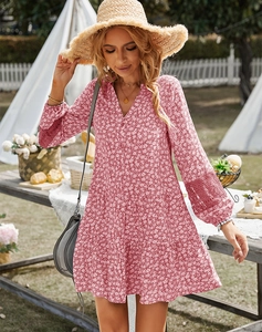 Detail of pink floral dress featuring lace stitching on long sleeves and layered hemline