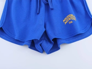 Détail du short bleu délavé avec imprimé Michigan jaune et cordon de serrage