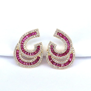 Curved golden earrings with red rectangular stones and sparkling clear crystals set in pave