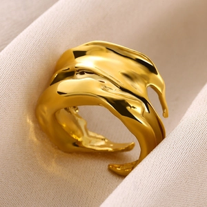 Detail of golden heart ring featuring irregular molten metal texture on silk fabric