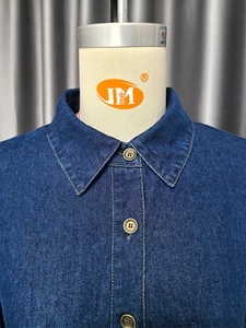 Dettaglio dell'abito in denim vintage con scollo a V, tessuto blu scuro e cuciture a contrasto