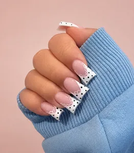 Detail of pink glitter duckbill press-on nails with white French tips and black dots