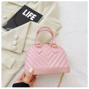 Detailed view of pink jelly bag with V-shaped texture and gold chain strap