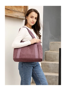 Deep purple canvas tote bag with metal snap button and webbing handles shown on model